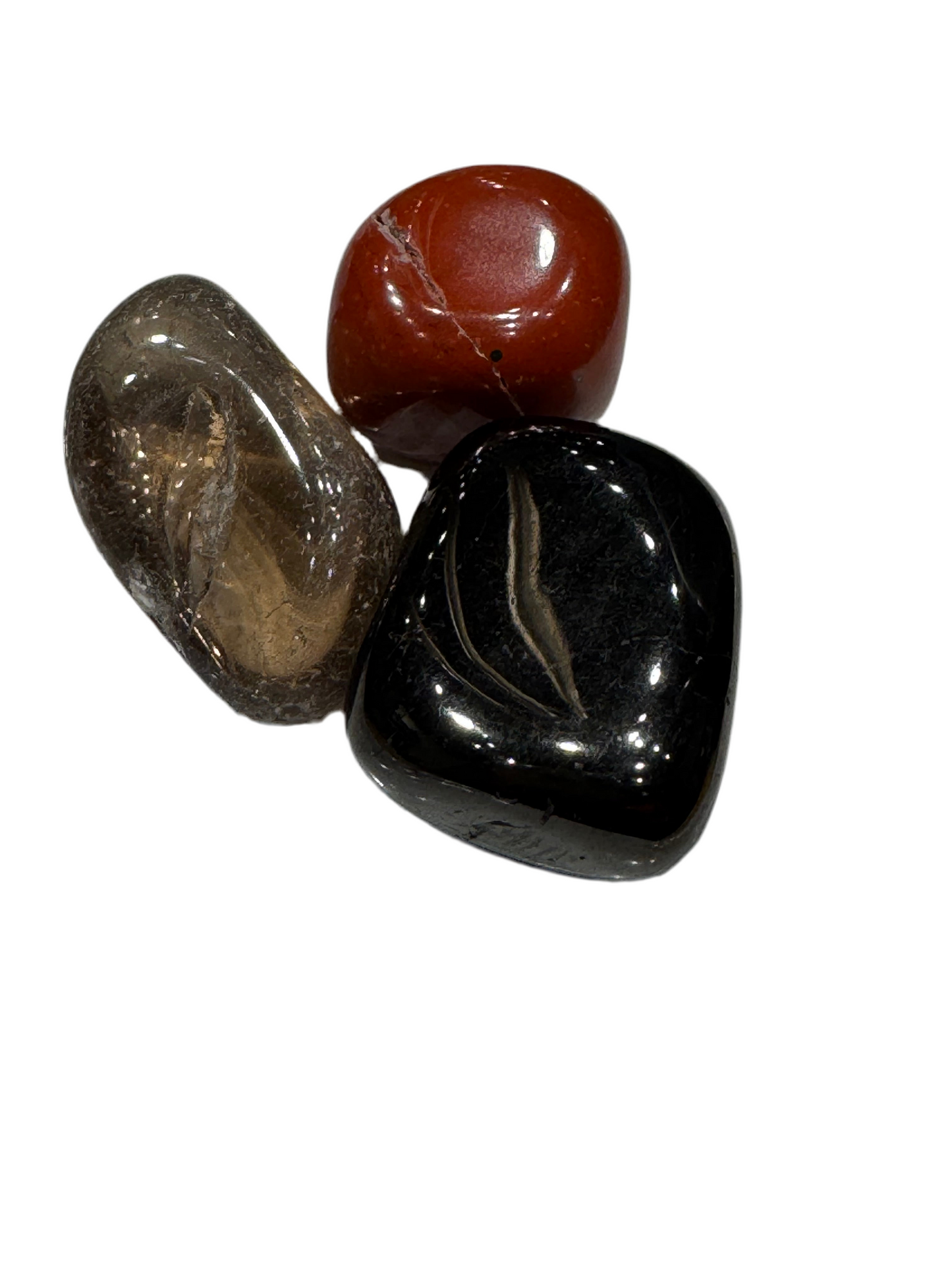 Three polished stones of different colors on a white background