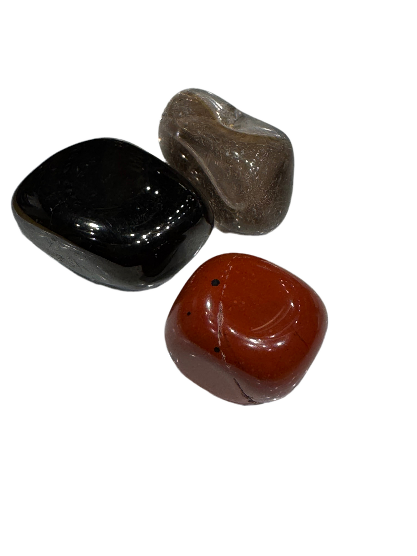 Three rocks of different colors on a white background
