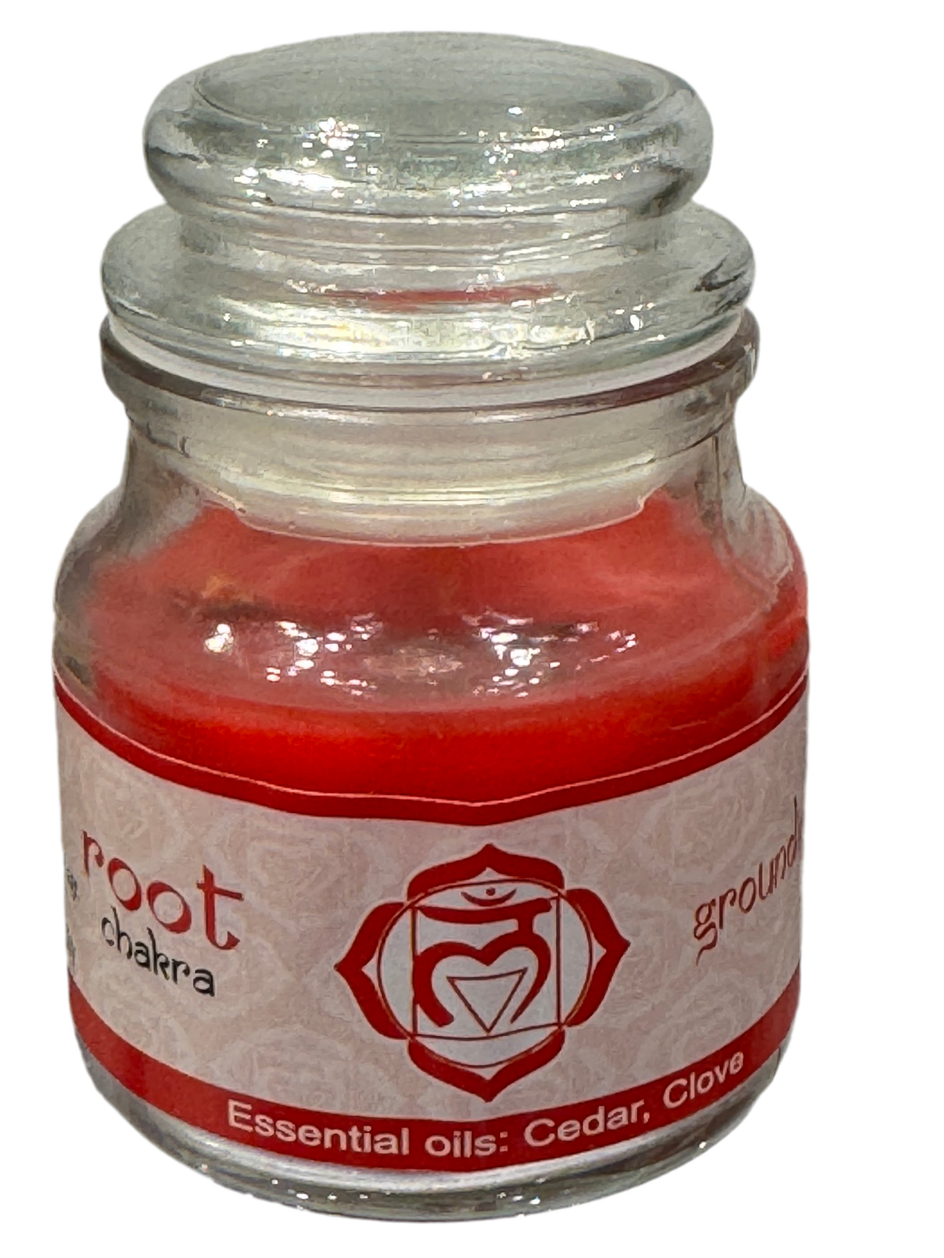 Small glass jar with a red candle and label on a white background